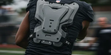 Football player wearing a modern, protective backplate on the field