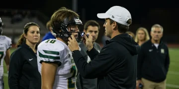 High school football player undergoing concussion evaluation on sideline