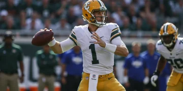 Dynamic rookie quarterback throwing a pass on the field